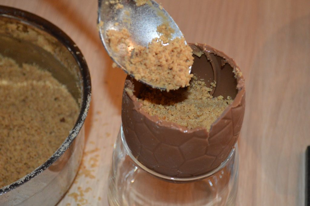 How to make Cheesecake Chocolate Eggs - fill the chocolate egg with biscuit base mix